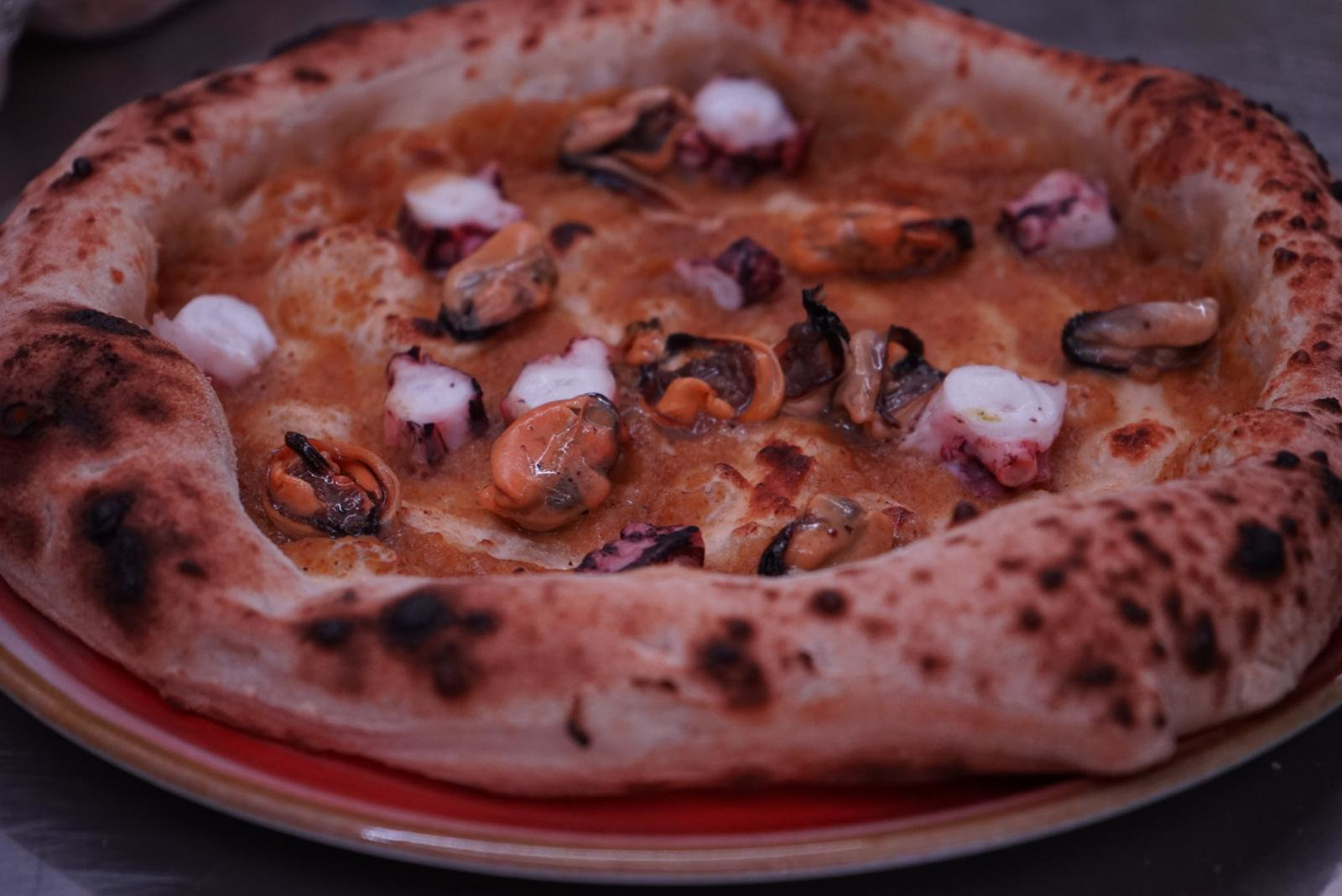 Pizza con ingredienti del mare appena cotta nel forno a legna della Torre del Cupo
