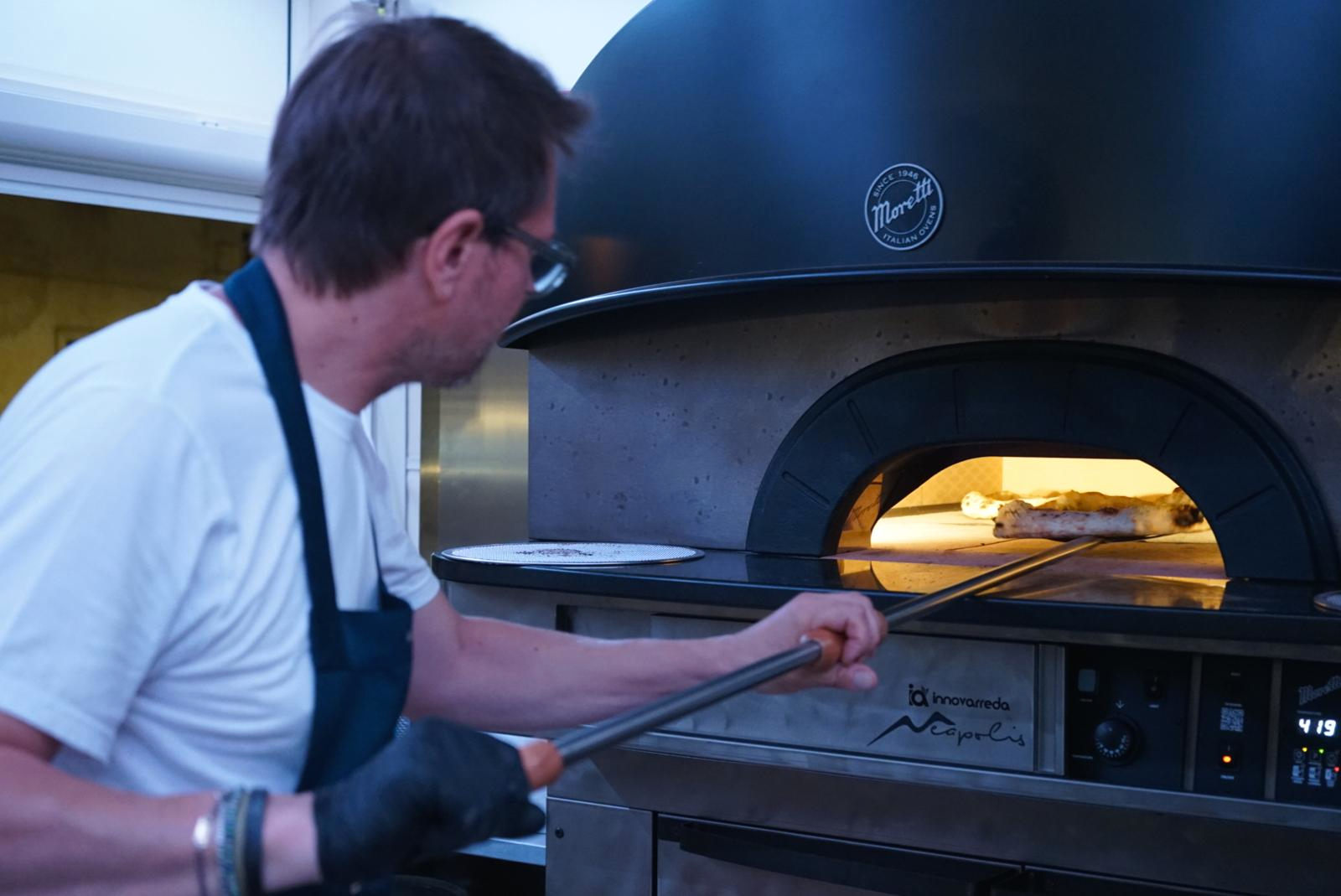 Pizzaiolo inforna la pizza a Schiavonea di Corigliano Rossano