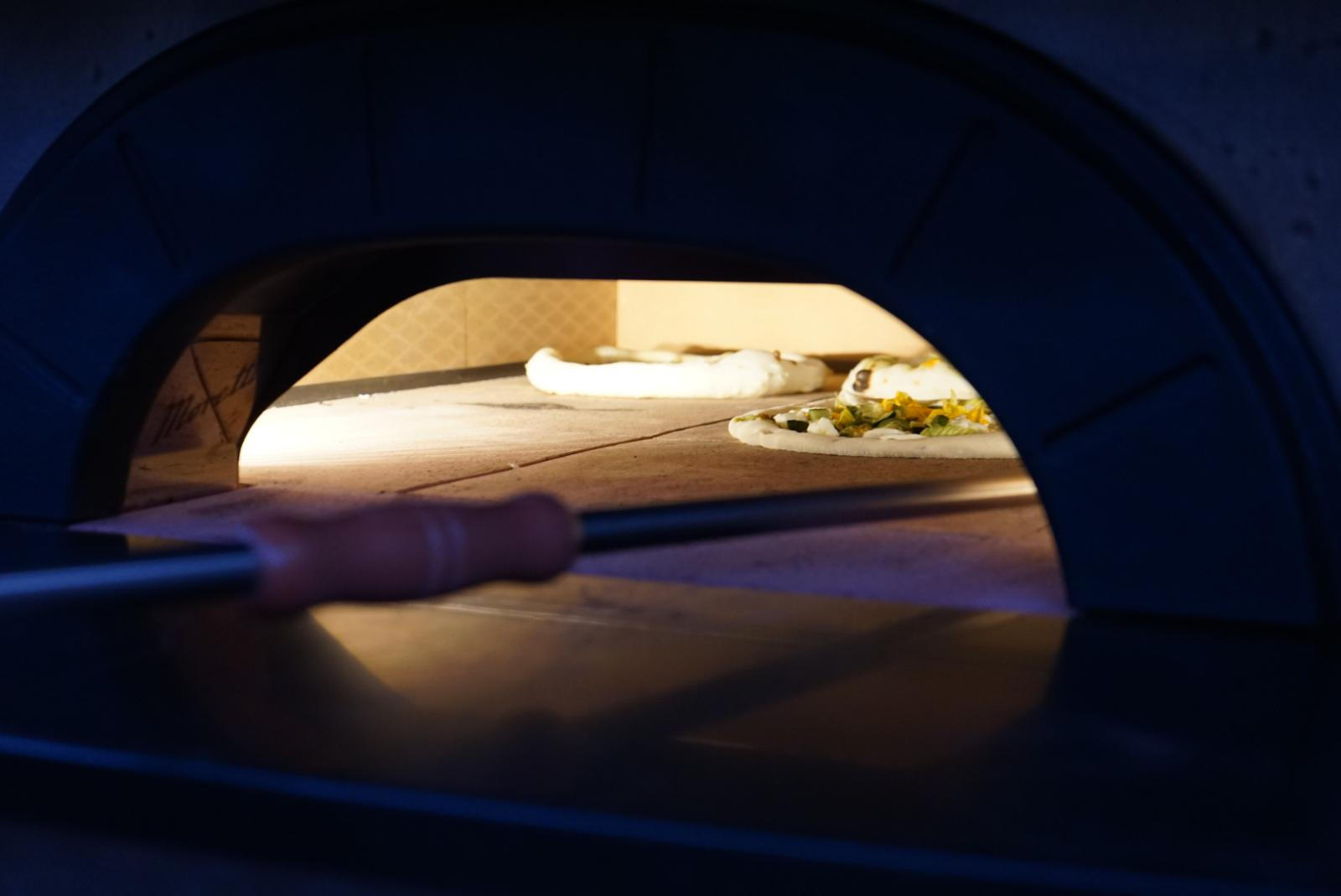 Cottura della pizza dopo il processo di lievitazione a Schiavonea nella pizzeria di Torre del Cupo